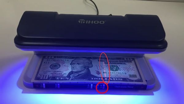 El detector Tihoo T0020 verifica eficazmente un billete de 10 USD, destacando sus elementos de seguridad.